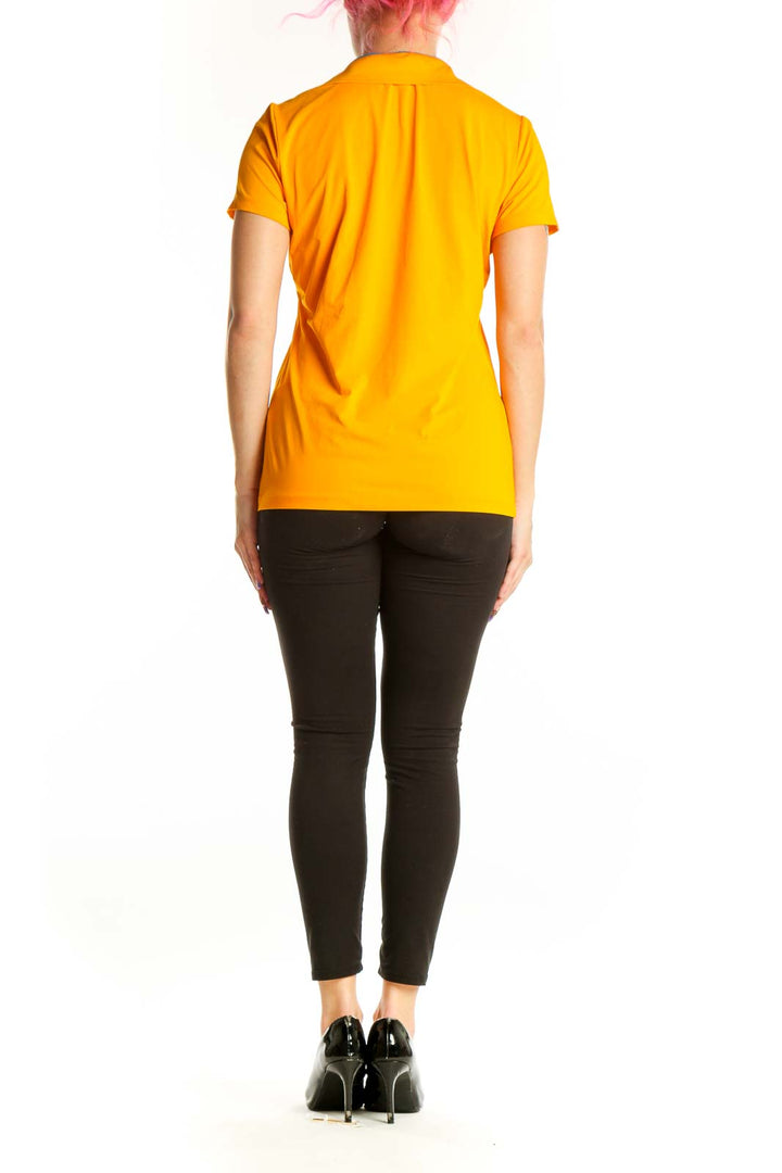 Yellow short sleeve polo top by Louis Castel, back view on model wearing black pants