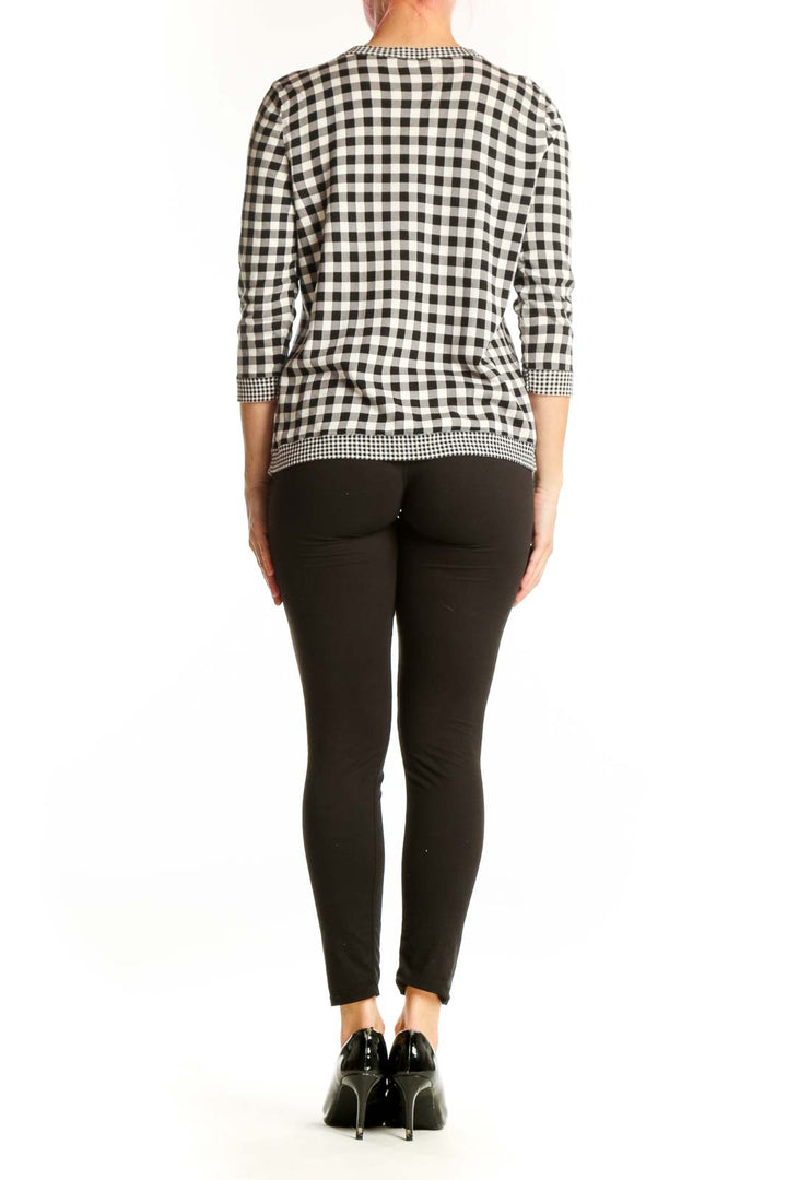 Back view of black and white gingham cardigan showing three-quarter sleeves and beaded hem detail
