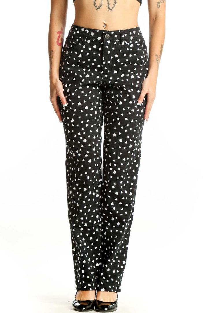 Front view of black straight-leg pants with white heart pattern