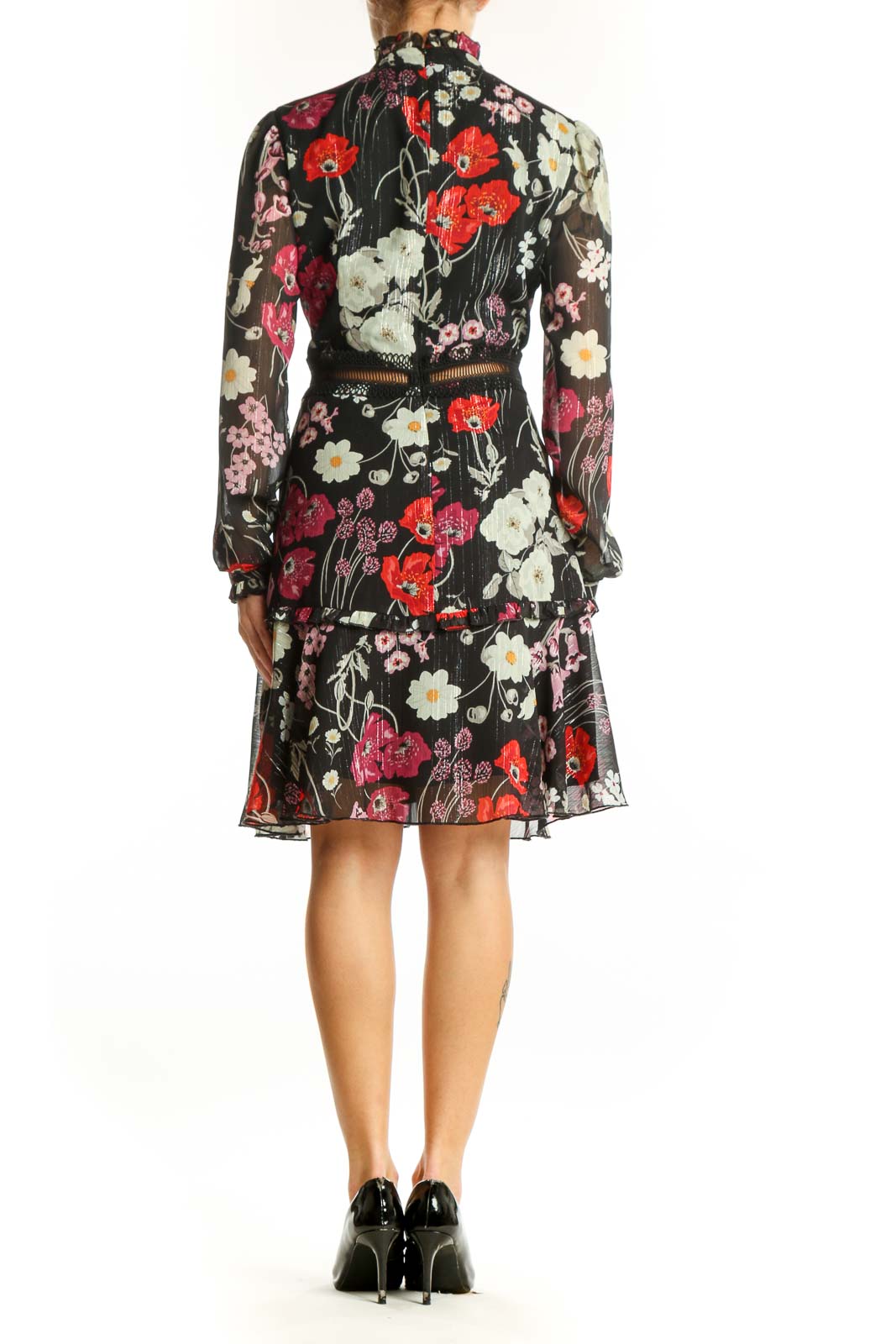 Side view of Donna Morgan black floral print chiffon cocktail dress showing flounced hem and gold-toned belt