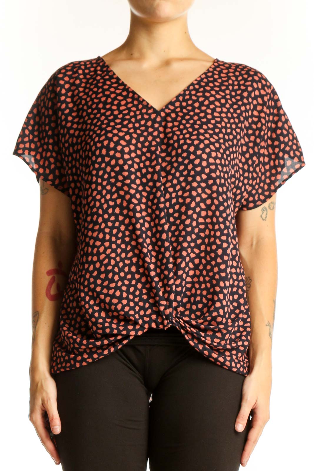 Front view of West Kei Black and Coral Spotted V-Neck Blouse with twist-front hem
