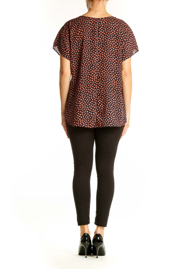 Side view of West Kei Black and Coral Spotted V-Neck Blouse showing drape and fit