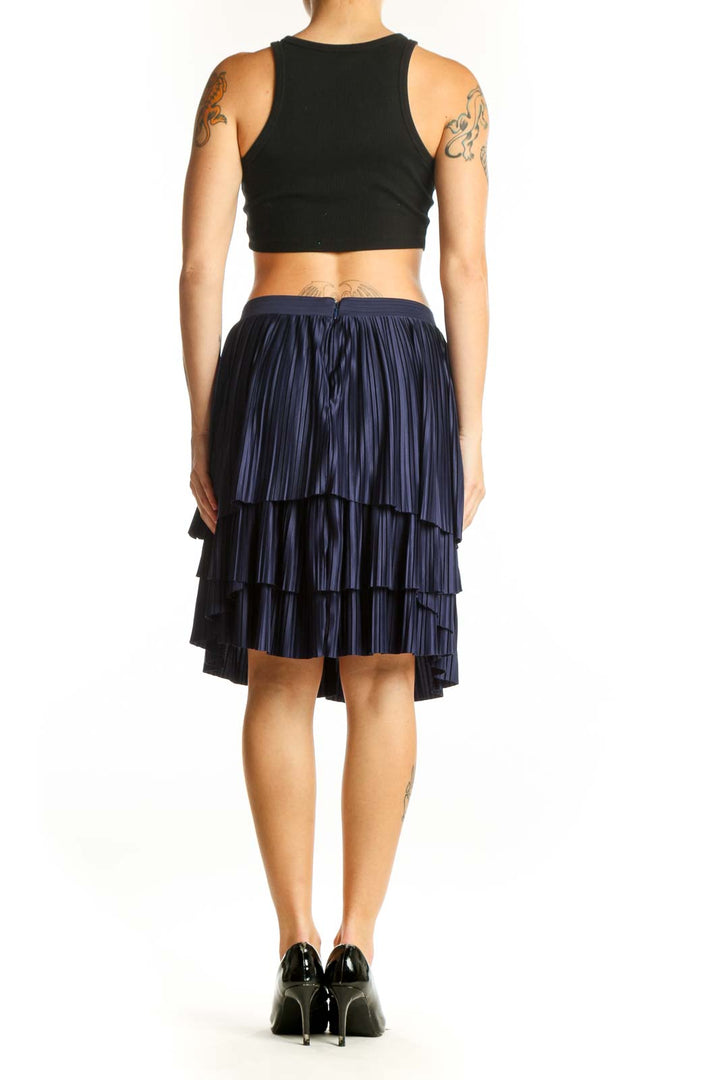 Side view of navy pleated tiered skirt with black top