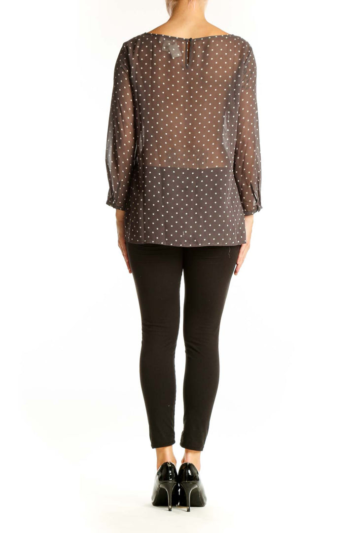Side view of model wearing LOFT brown polka dot sheer blouse with black pants