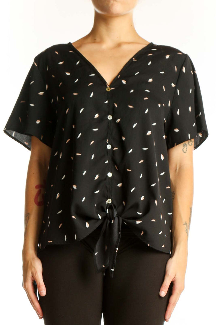 Front view of West Kei black blouse with white leaf pattern and tie-front detail