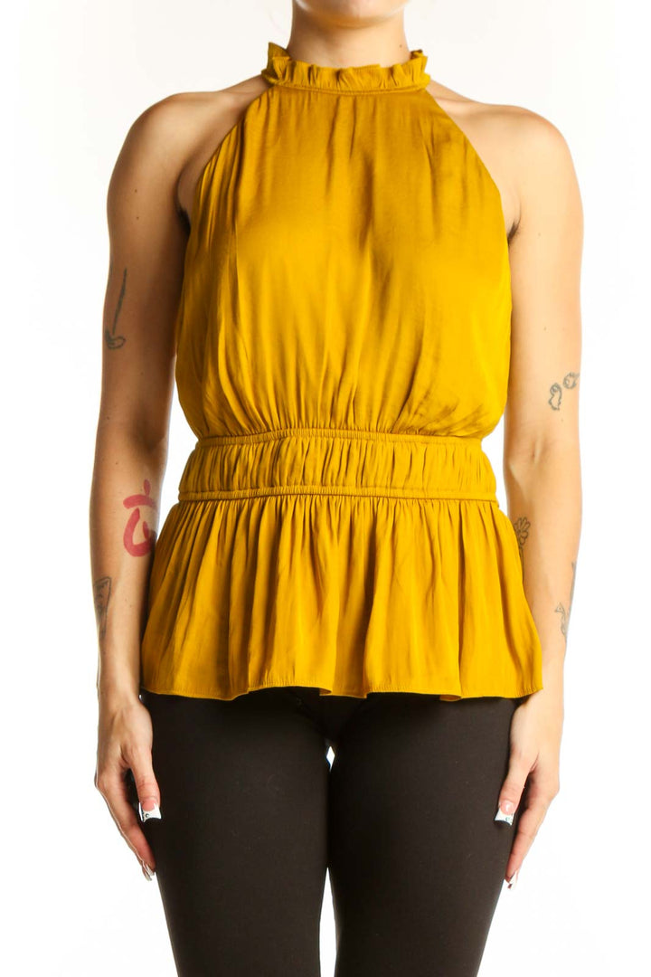 Front view of Nine West mustard sleeveless top with ruffled neckline and peplum waist