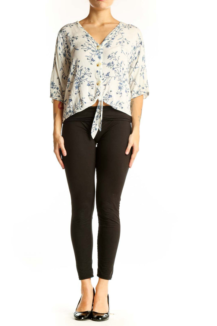 Front view of white Luq blouse with blue floral print and tie-front detail