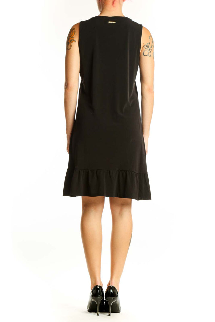 Black sleeveless shift dress with ruffle hem detail, back view