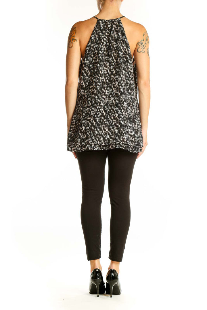Side view of Banana Republic black patterned sleeveless blouse showing layered asymmetrical hem