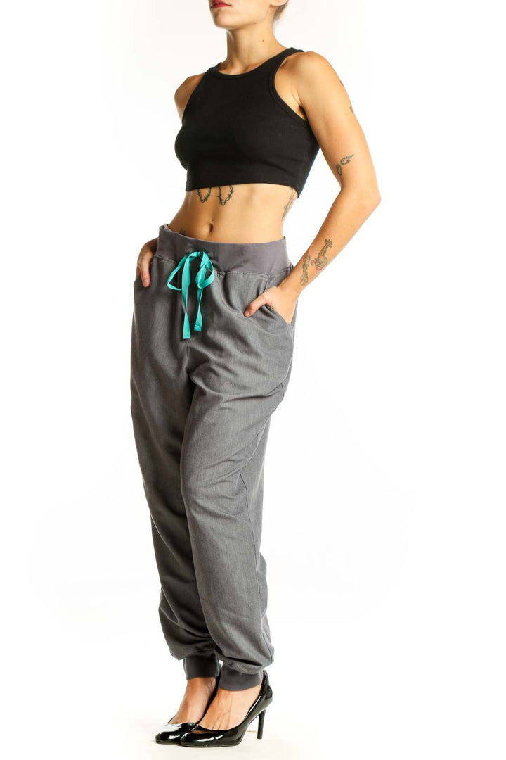 Front view of gray FIGS jogger pants with teal drawstring