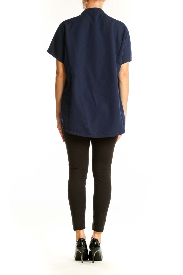Side view of navy FIGS top showing relaxed fit and short sleeves
