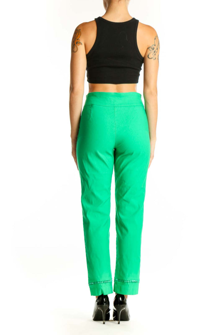 Side view of woman wearing green Crown & Ivy pants with black top