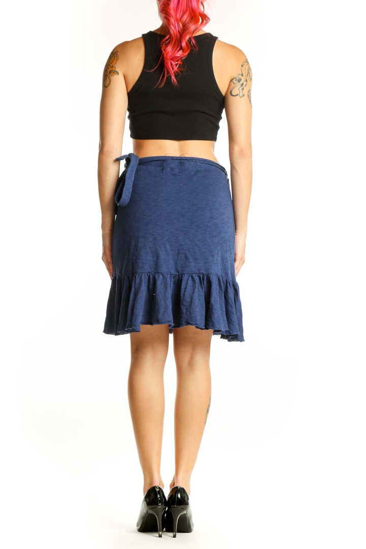 Back view of navy cotton mini skirt showing tiered ruffle design and asymmetrical hemline