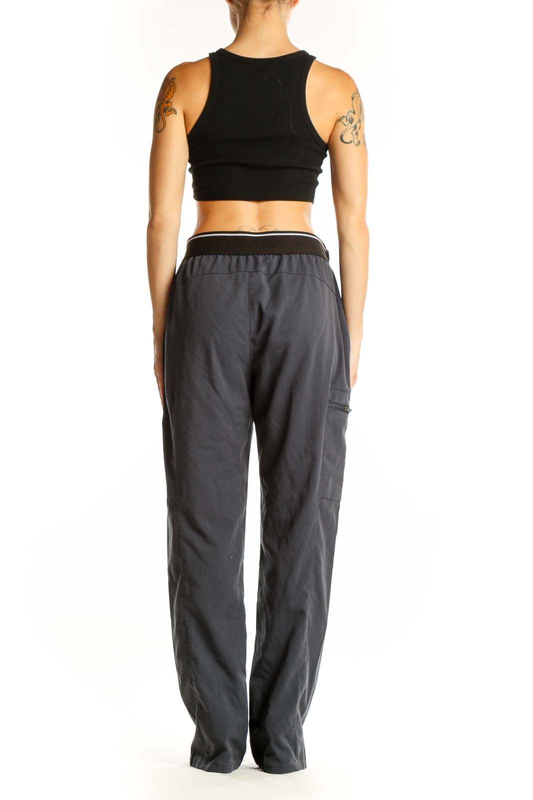Side view of woman wearing GREY'S ANATOMY gray scrub pants with black top