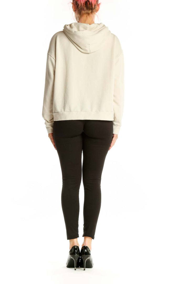 Back view of cream hooded sweatshirt jacket showing relaxed fit and hood design