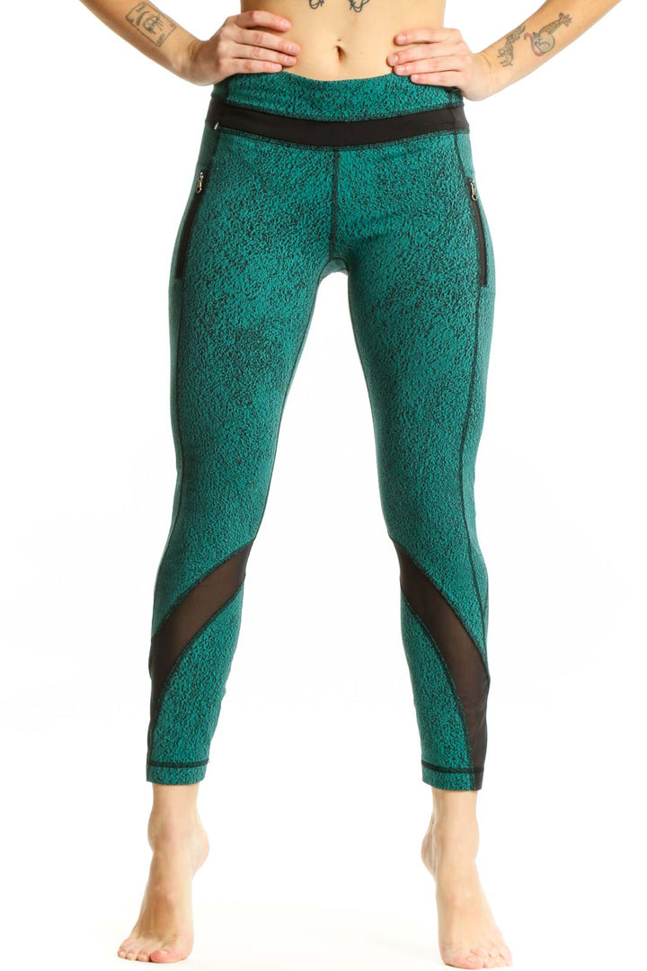 Front view of teal heathered Lululemon crop leggings with black mesh panel inserts and high-waisted design