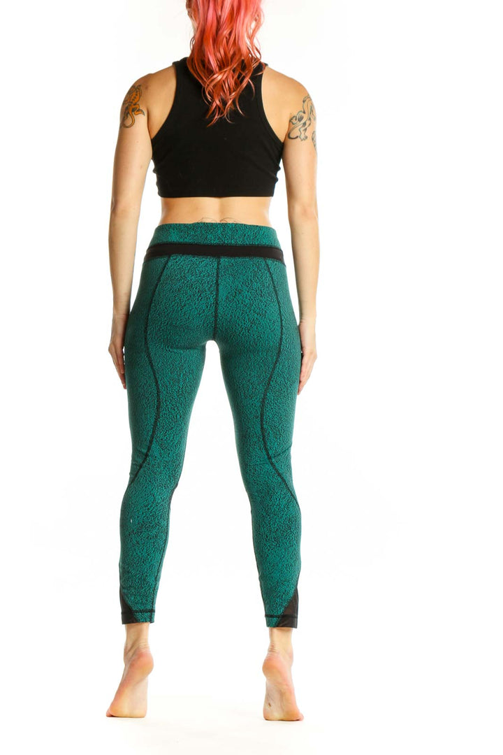 Back view of teal heathered Lululemon crop leggings showing mesh panels and high-waisted silhouette
