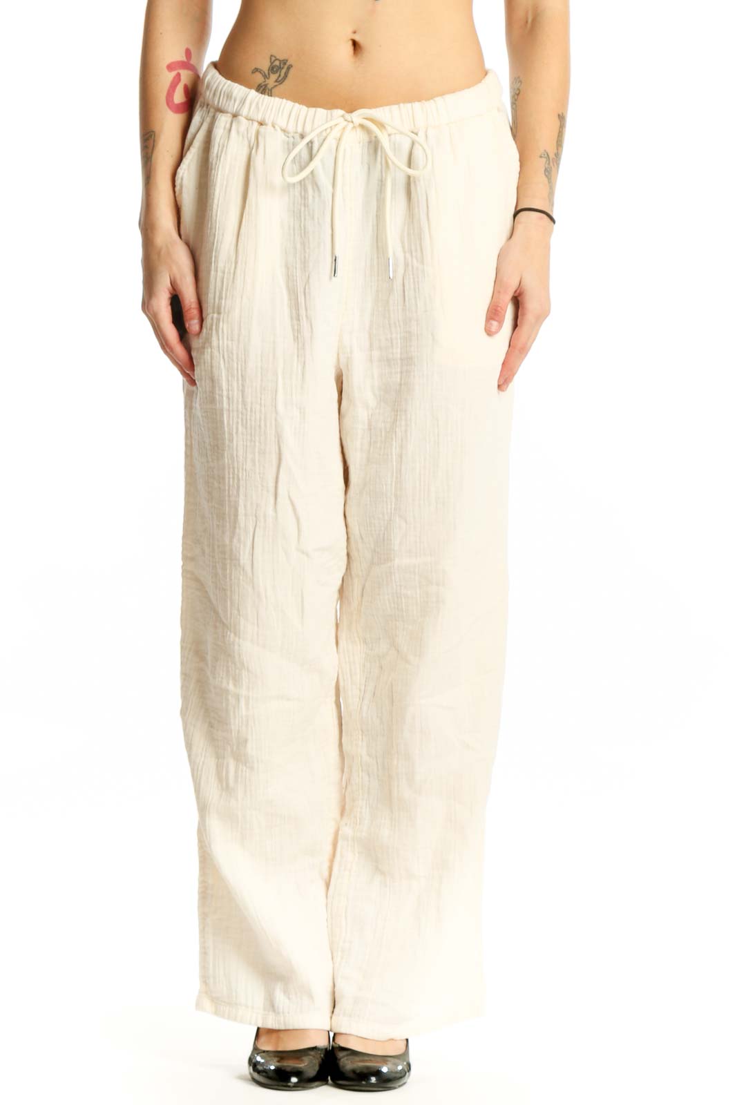Front view of cream organic cotton drawstring pants with relaxed wide-leg fit and adjustable waist