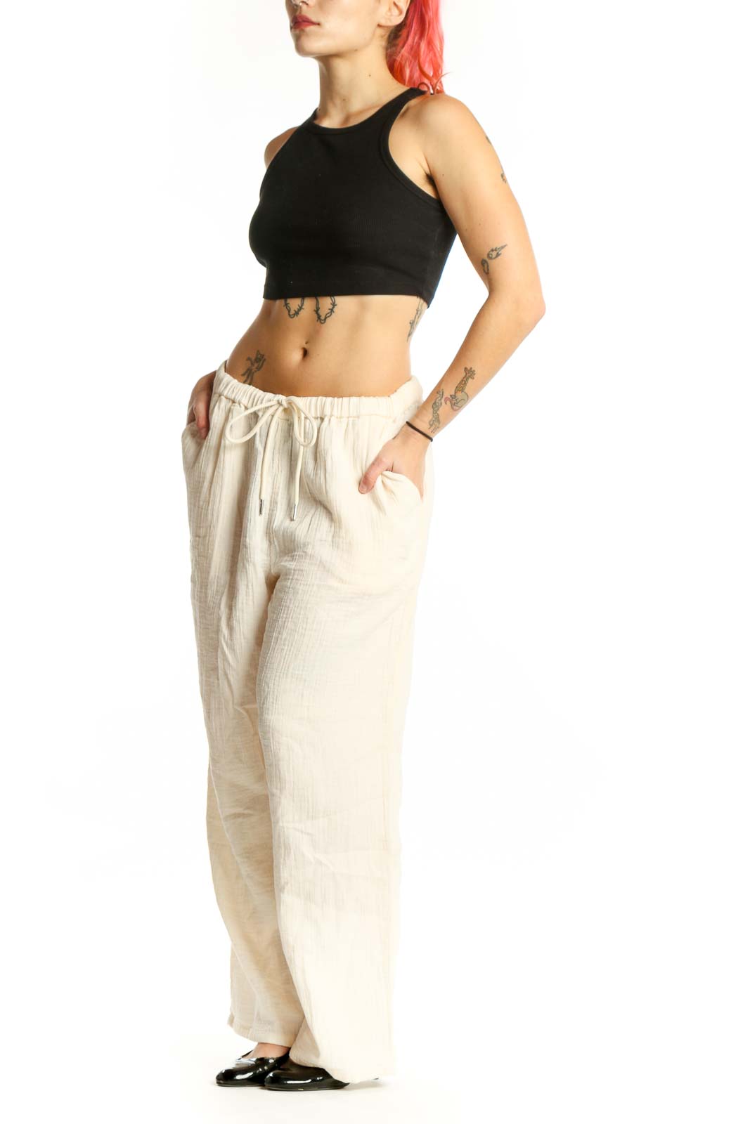 Front view of cream organic cotton drawstring pants with relaxed wide-leg fit and adjustable waist