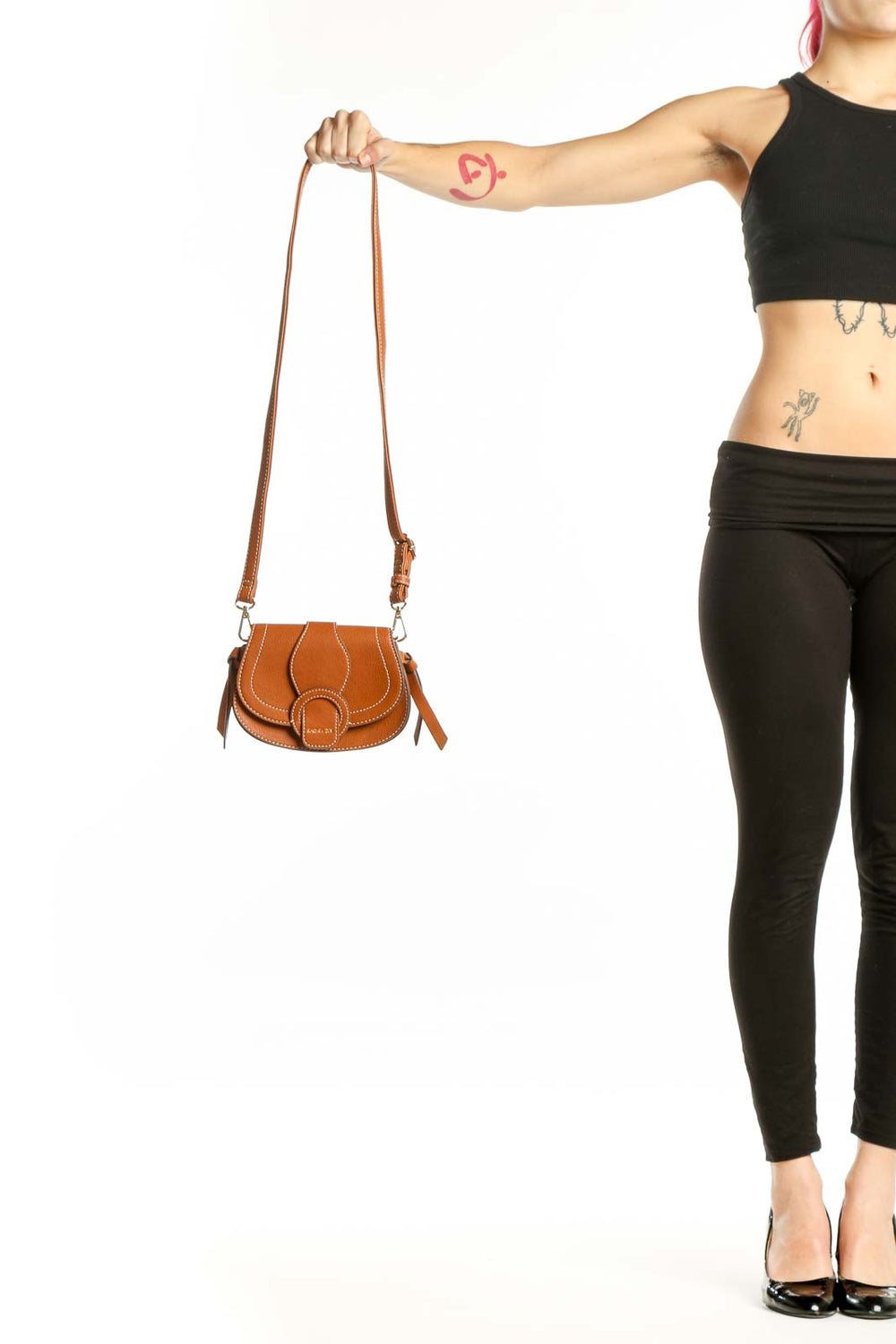 Cognac leather saddle crossbody bag by Rachel Zoe with white topstitching and adjustable leather straps, front view