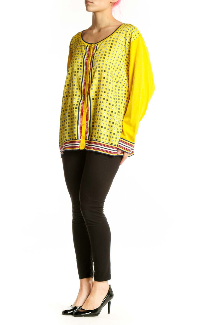 Yellow geometric print cardigan top with red and white striped trim, front view on model