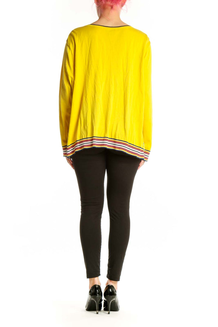 Yellow geometric print cardigan top with solid yellow sleeves, back view on model