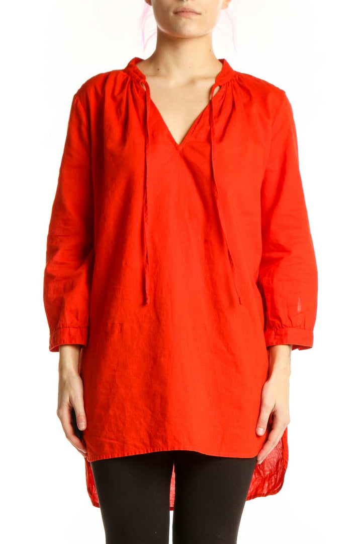 Red cotton-linen tunic top with V-neckline and drawstring ties, worn with black leggings