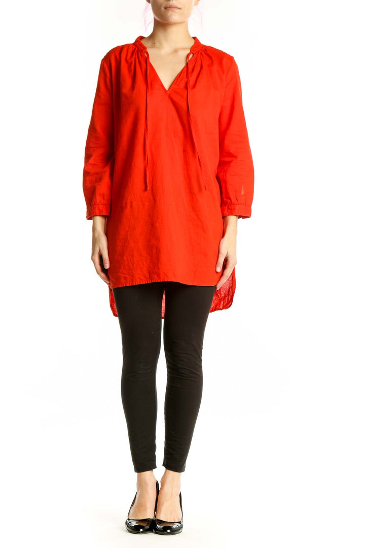 Red cotton-linen tunic top with V-neckline and drawstring ties, worn with black leggings
