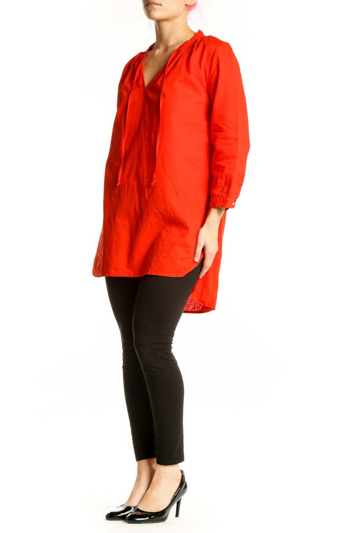 Red cotton-linen tunic top with V-neckline and drawstring ties, worn with black leggings