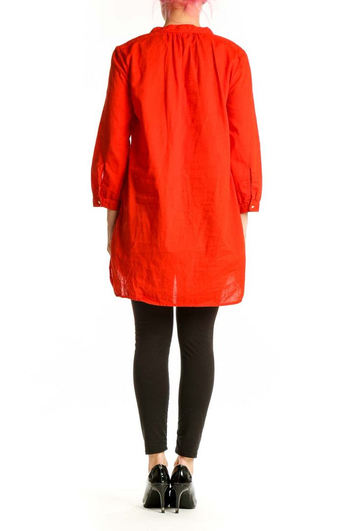 Back view of red tunic top showing high-low hem and long sleeves with gathered cuffs