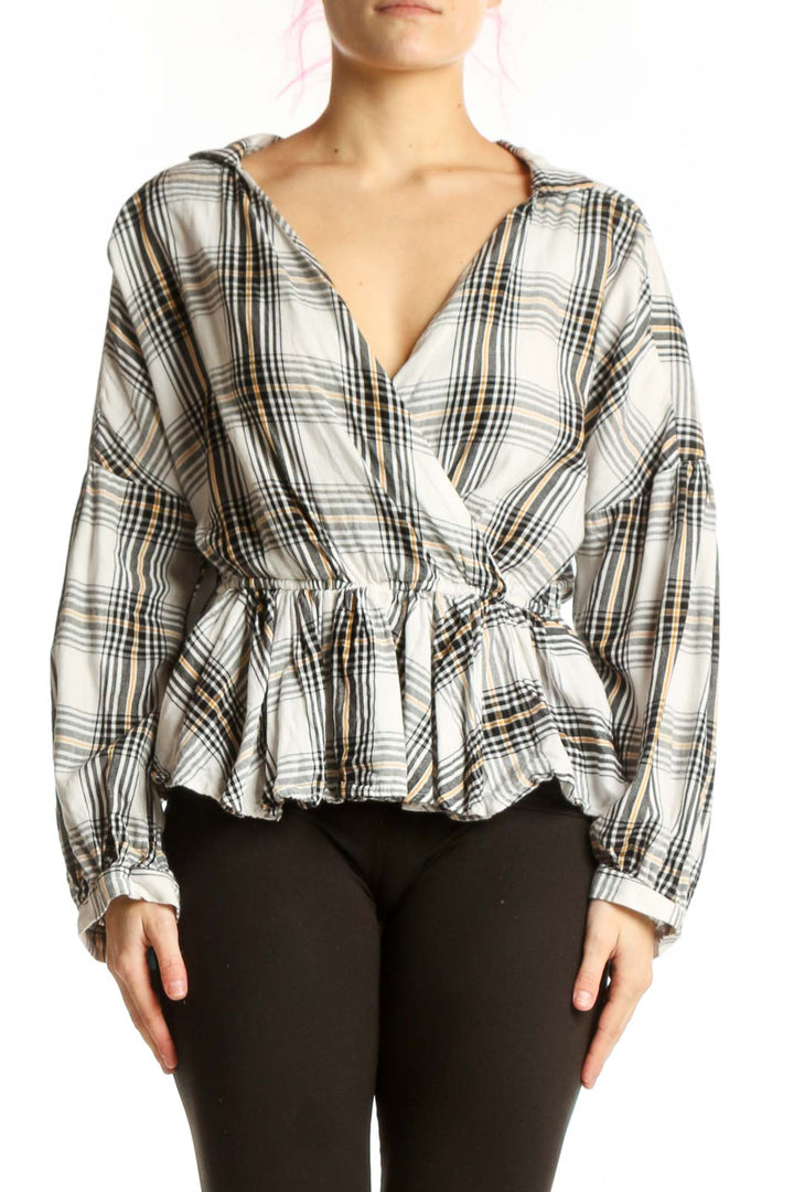 White and black plaid wrap top with peplum hem and long sleeves, front view