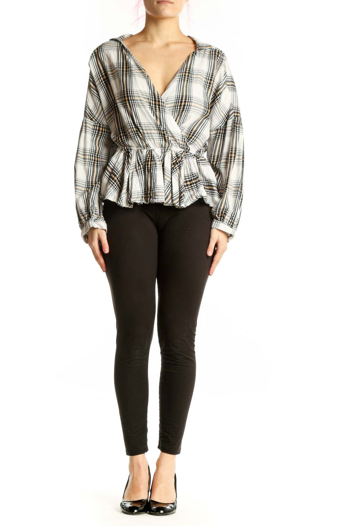 White and black plaid wrap top with peplum hem and long sleeves, front view