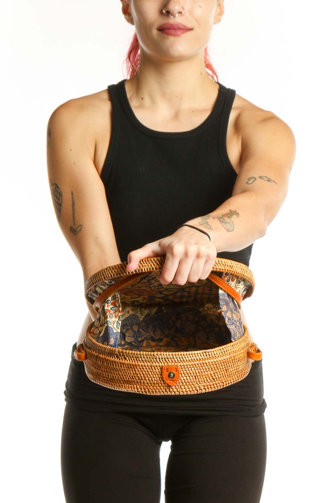 Woman wearing SilkRoll tan woven round shoulder bag crossbody style with black outfit