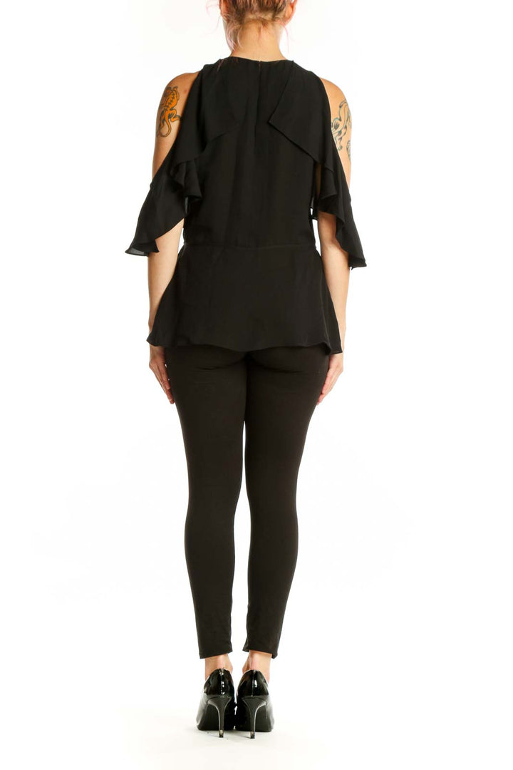 Black silk cold shoulder top with ruffled sleeves by Theory, back view showing elegant drape