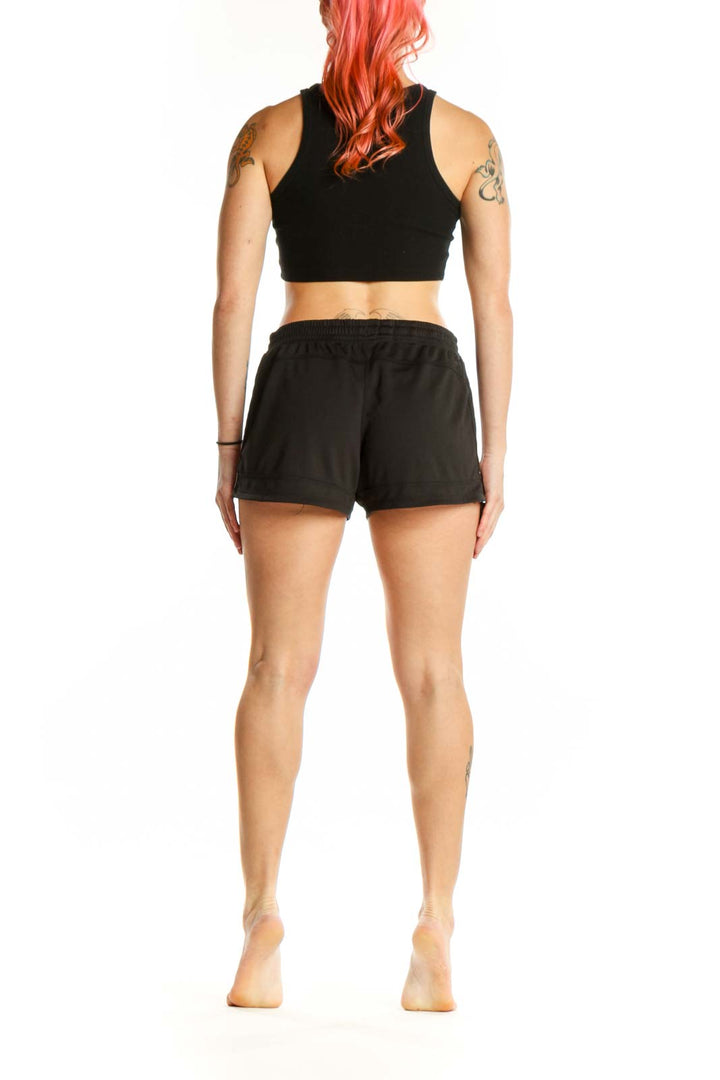 Black Adidas athletic shorts with three-stripe detailing, back view on model