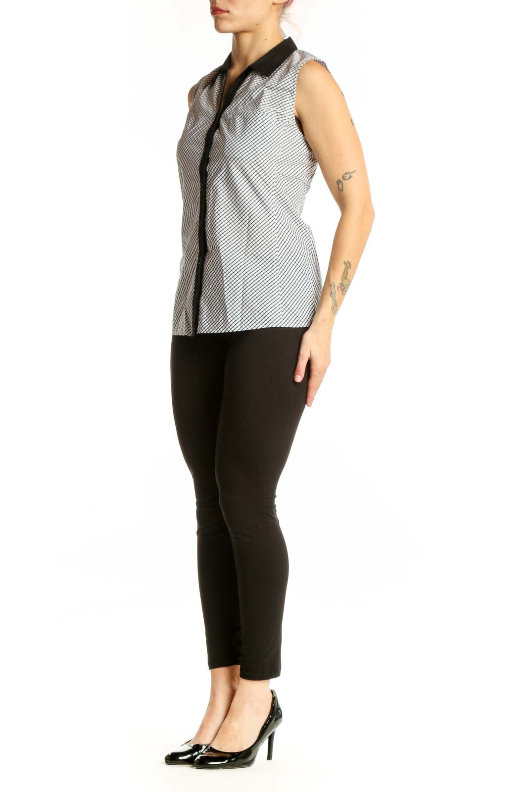 White diagonal striped sleeveless button-up top with black collar trim and contrasting black front placket, front view