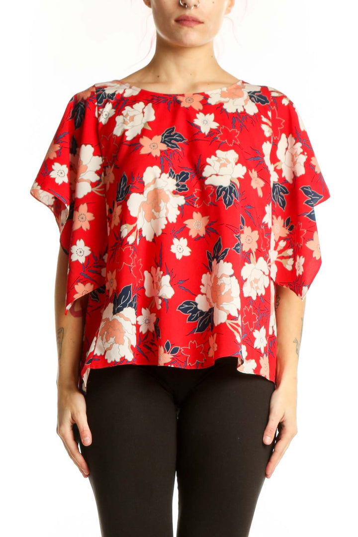 Red floral short sleeve blouse with cream and peach flowers, worn with black leggings