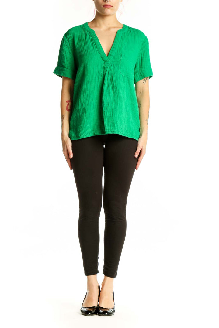 Woman wearing vibrant green V-neck cotton short sleeve top with relaxed fit