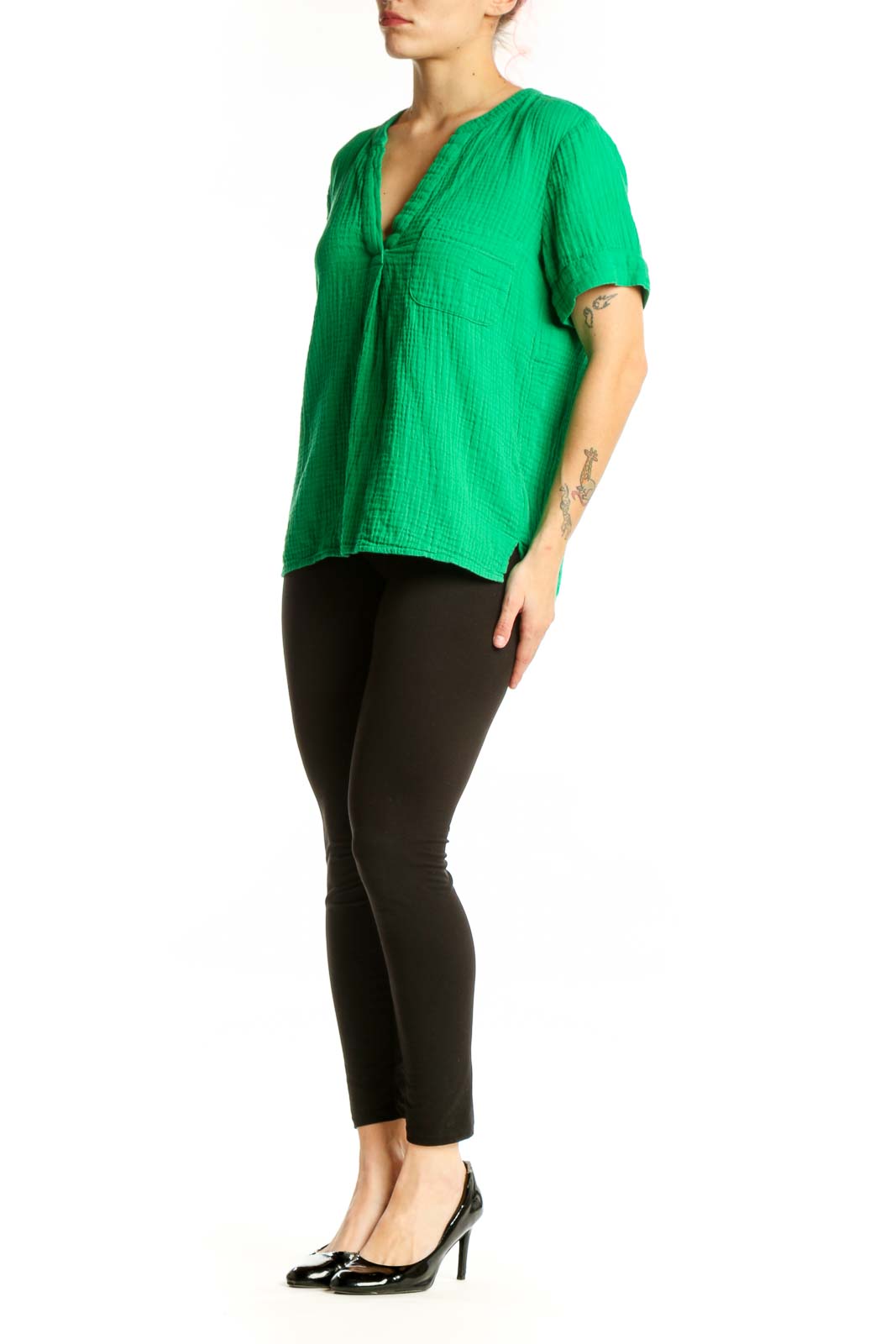 Woman wearing vibrant green V-neck cotton short sleeve top with relaxed fit
