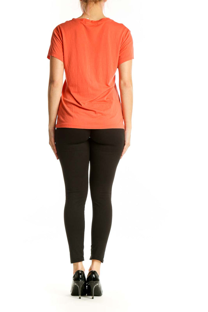 Orange graphic band t-shirt back view showing layered vintage band graphic design