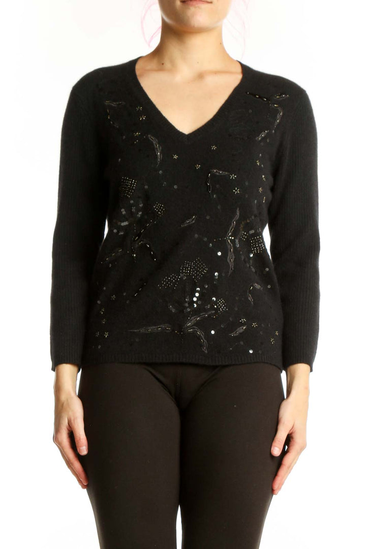 Black embellished merino wool pullover with beadwork and sequin detail, V-neckline, long sleeves, worn with black pants