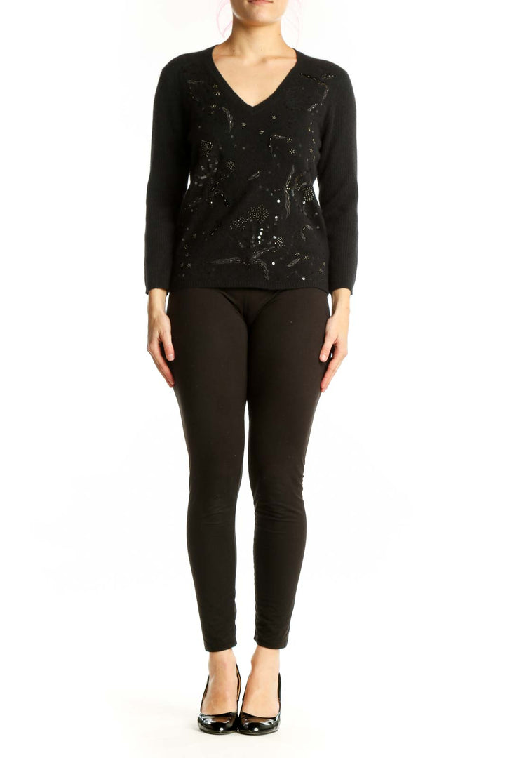 Black embellished merino wool pullover with beadwork and sequin detail, V-neckline, long sleeves, worn with black pants