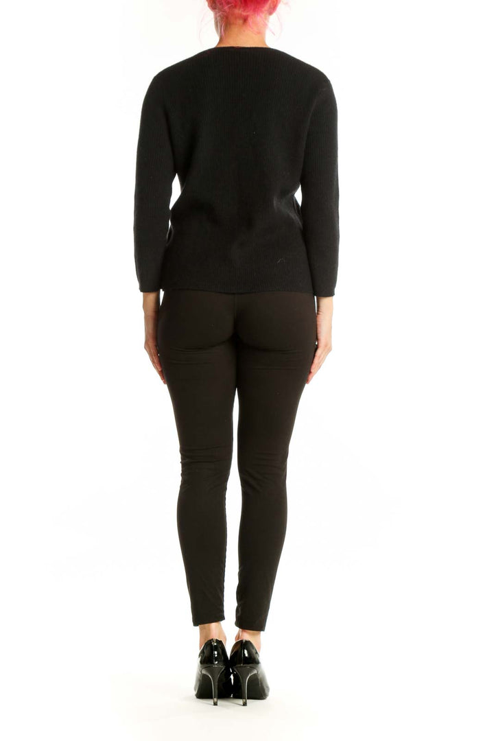 Back view of black embellished pullover showing intricate beadwork pattern, long sleeves, and fitted silhouette