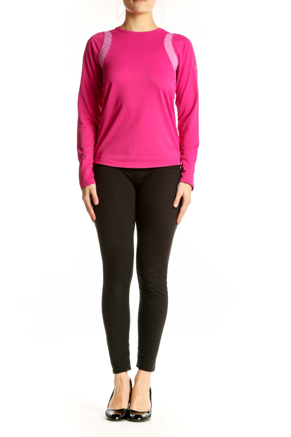 Front view of pink Nike long sleeve athletic top with mesh shoulder panels on model, paired with black leggings