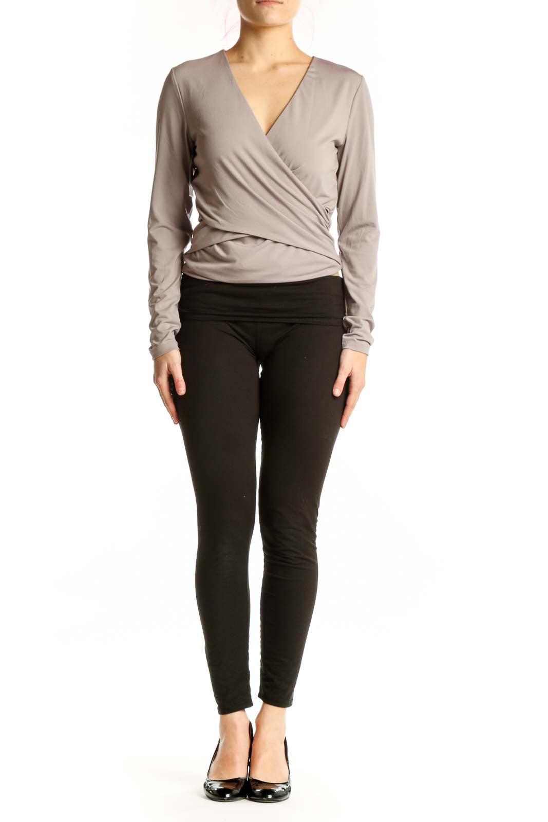 Beige wrap long sleeve top with flattering wrap-front design and fitted waist, paired with black leggings