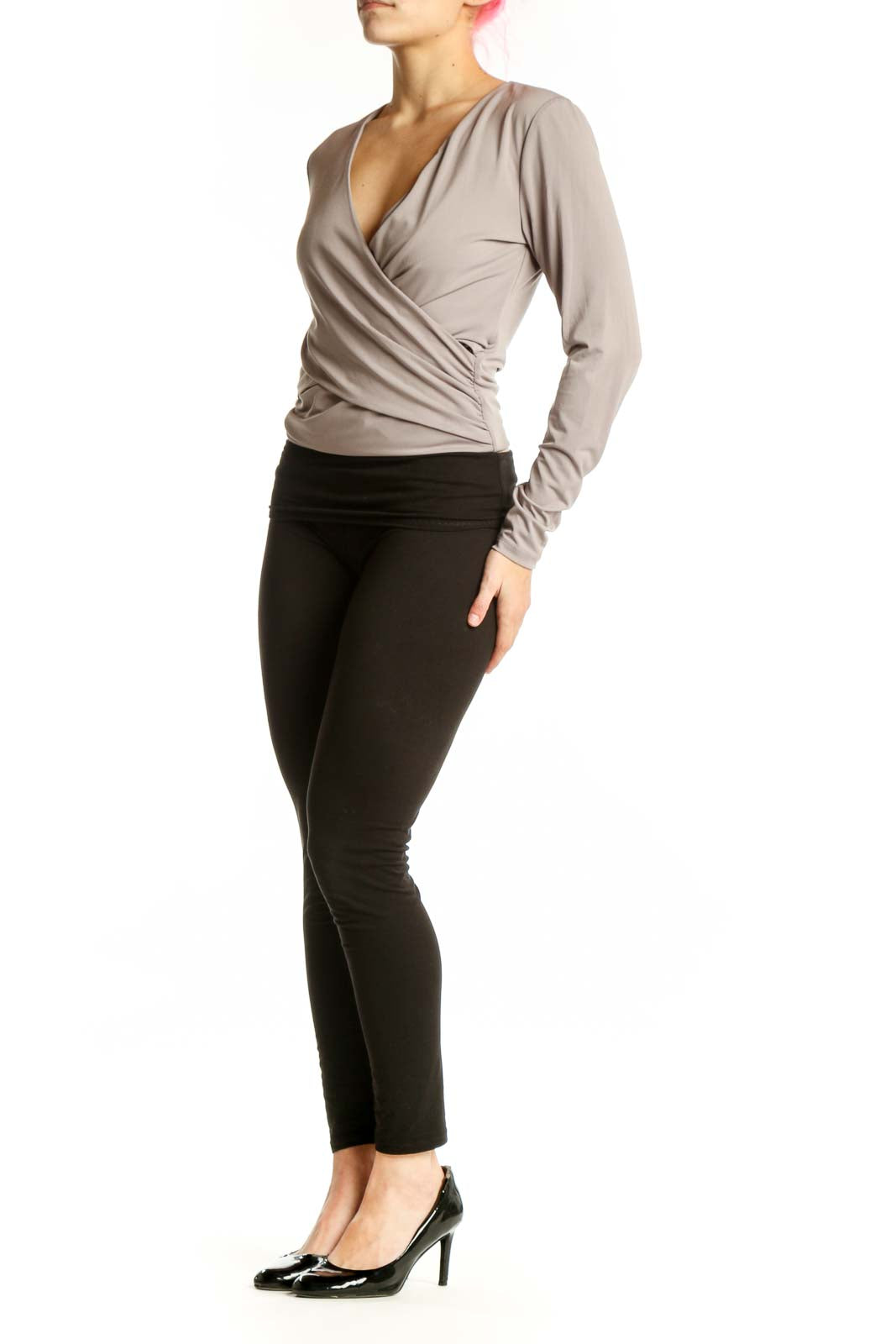 Beige wrap long sleeve top with flattering wrap-front design and fitted waist, paired with black leggings
