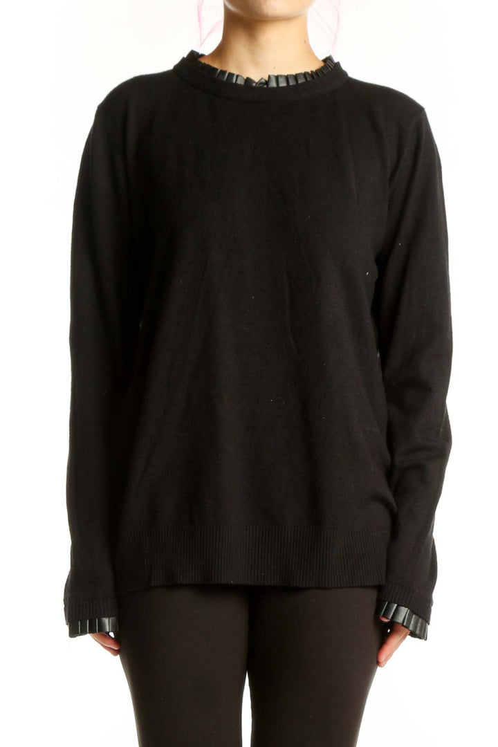 Black knit sweater with ruffle trim neckline and cuffs, front view on model