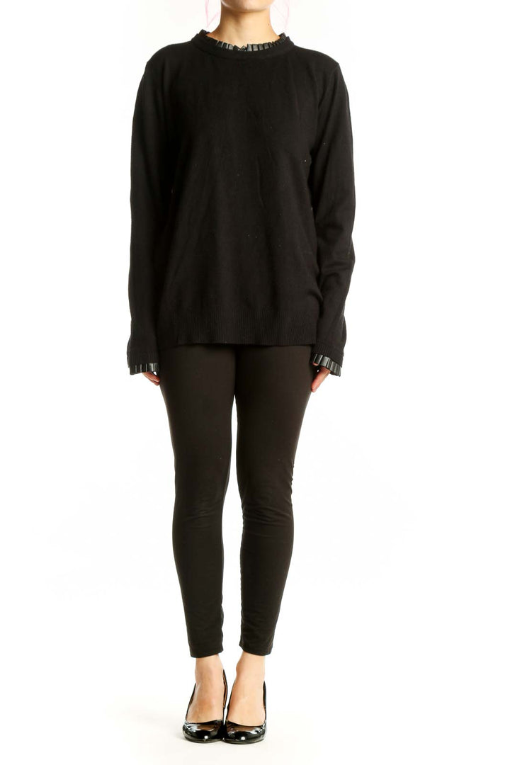 Black knit sweater with ruffle trim neckline and cuffs, front view on model