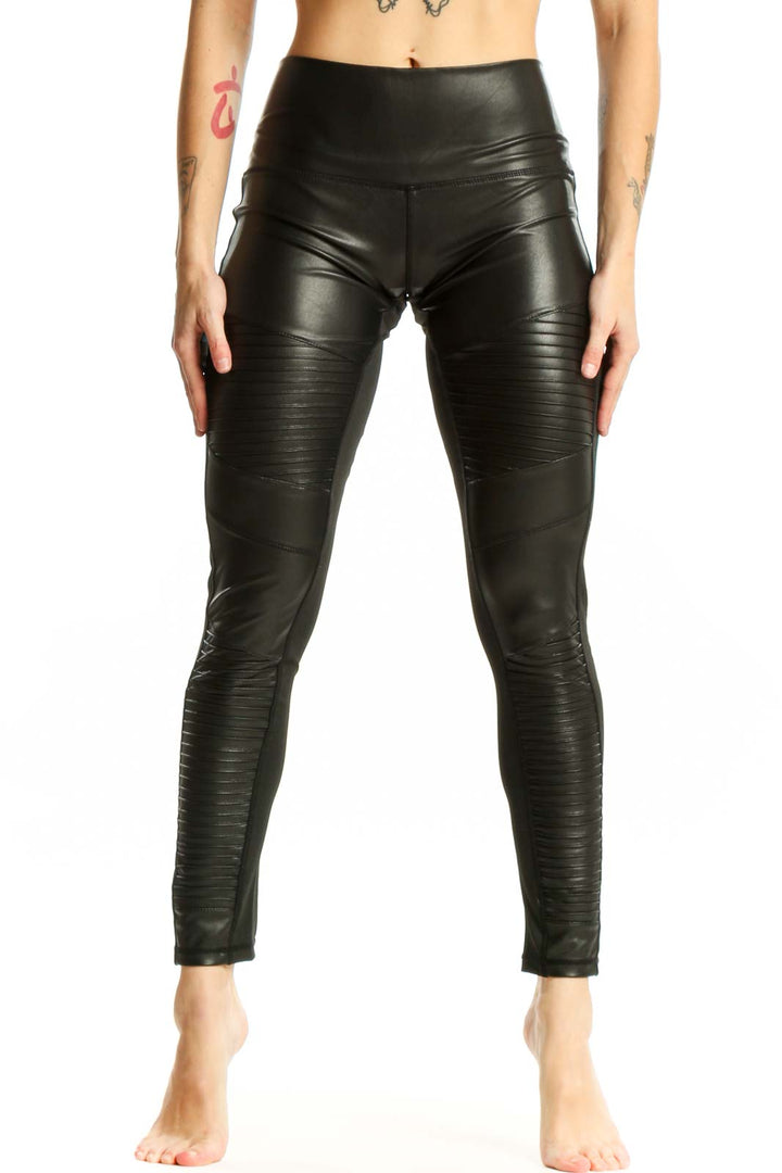 Black ruched faux leather leggings front view, high-waisted design with textured pattern