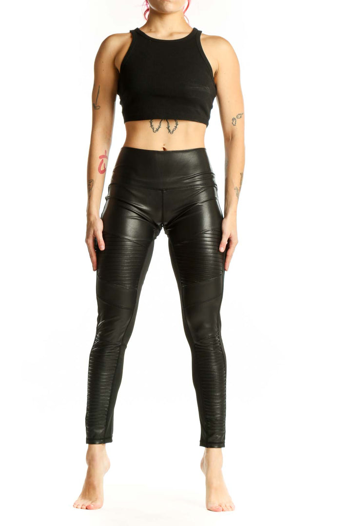 Black ruched faux leather leggings front view, high-waisted design with textured pattern
